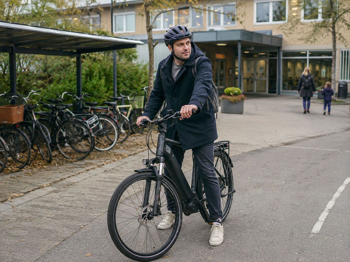 Cyklist med cykelhjelm ved skole