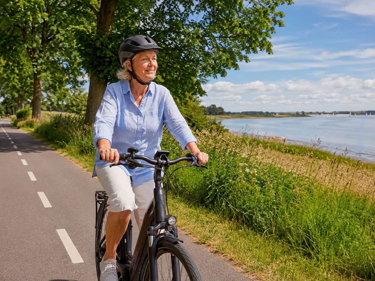 Cyklist med cykelhjelm paa tur ved soeen
